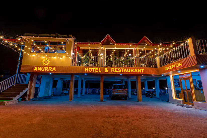 Anurra Hotel and Restaurant lit up after dark, festoon lights along the terrace and covered parking below