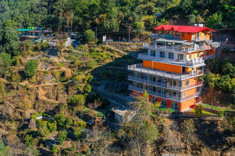 The hotel and the terraced slope below it, seen from above in afternoon light